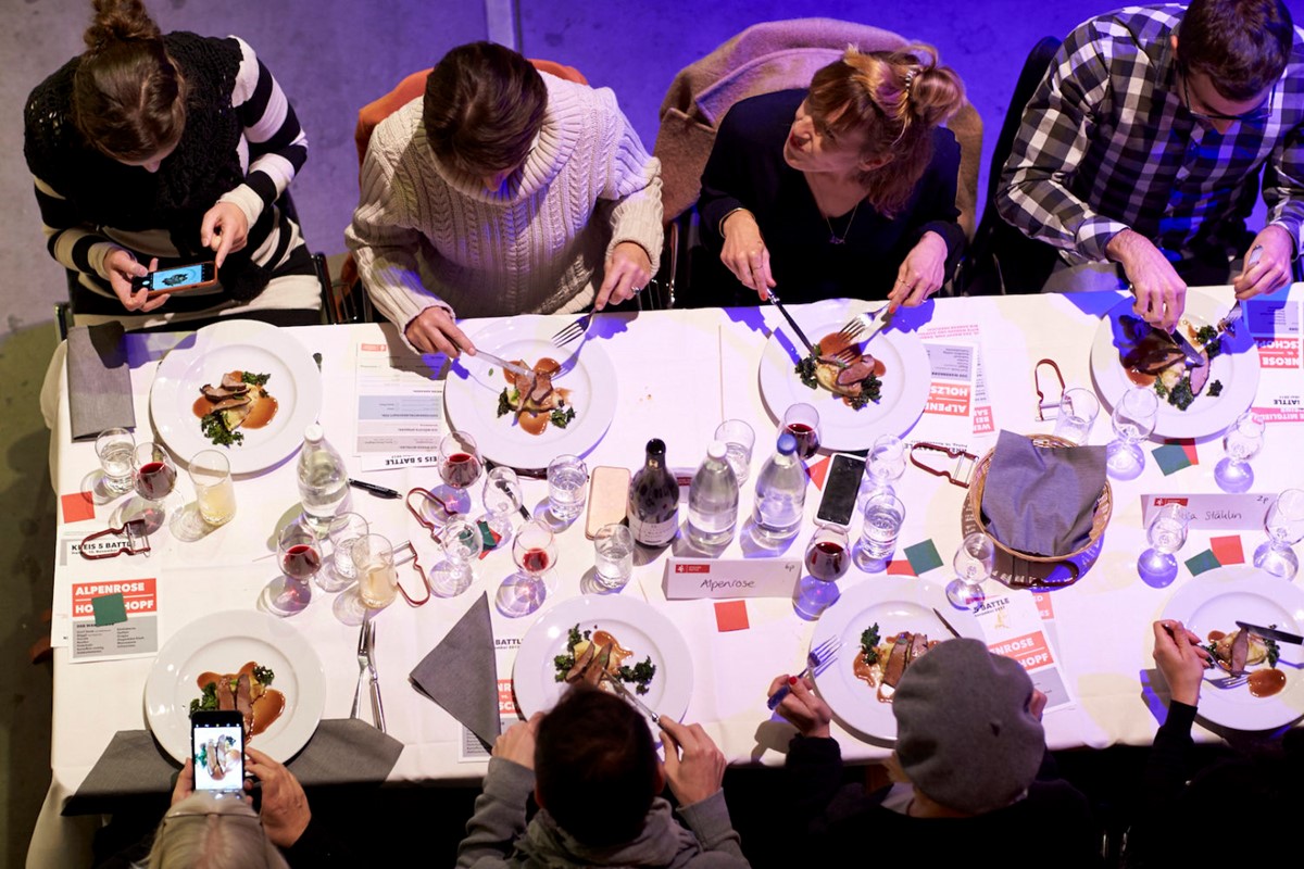 Gäste sitzen gemeinsam an der langen Tafel, bewerten die Köche und tauschen sich aus – so schnell kommen Fremde miteinander ins Gespräch. Das ist ein wichtiger Grund für den Erfolg des Kitchen-Battle-Konzepts.